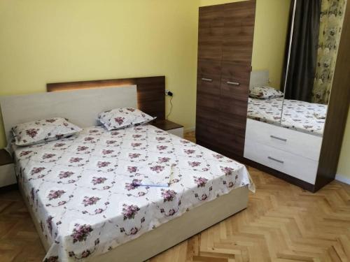 a bedroom with a bed and a dresser and a mirror at В сърцето на Варна ви очаква прекрасен и просторен апартамент in Varna City