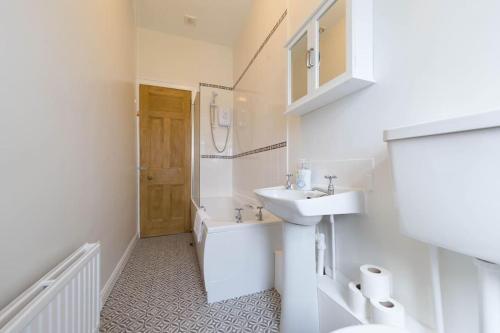 Baño blanco con lavabo y aseo en The Riverside Apartment (free parking), en Stirling