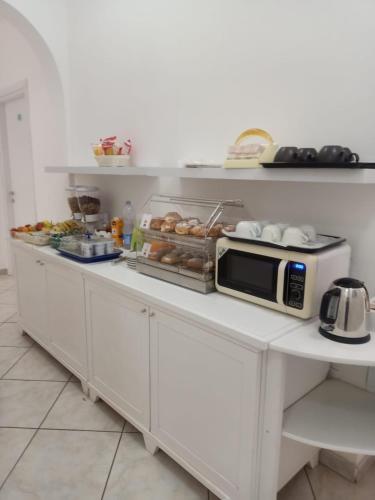 una cucina con un bancone con un microonde sopra di Affittacamere Da Angela a Villasimius