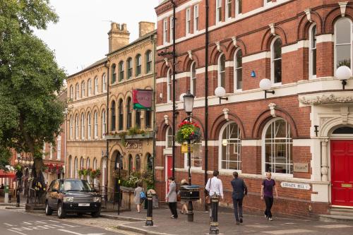 a group of people walking down a street in front of buildings at The Jewellery Suites Birmingham in Birmingham
