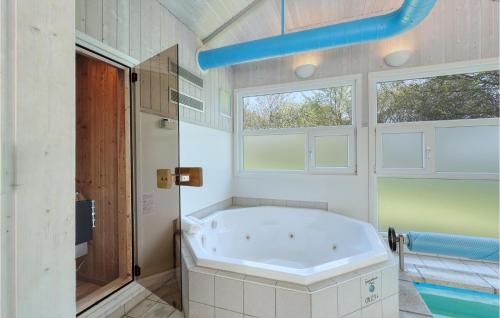 a large bathroom with a tub and two windows at Poolhaus 2 In Hohendorf in Hohendorf