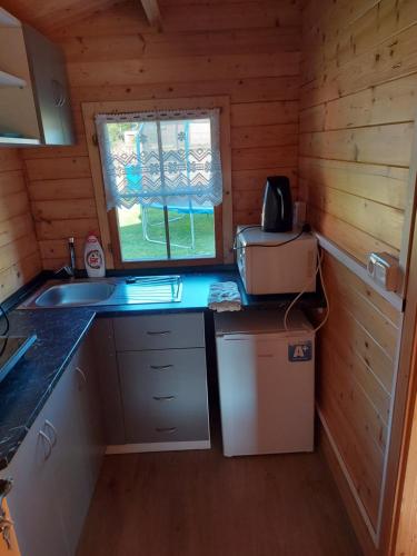 Cabaña de madera con cocina con fregadero y microondas en Chatička Evička, en Suchý