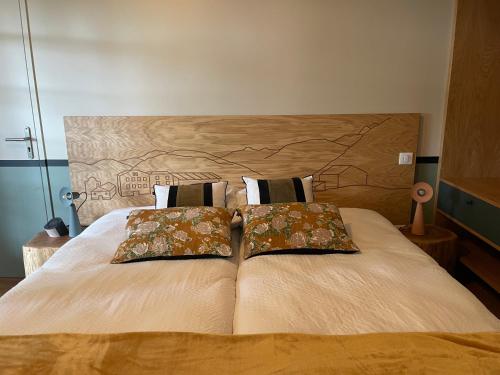 サン・ペ・シュル・ニヴェルにあるHotel Trinquetのベッド1台(上に枕2つ付)