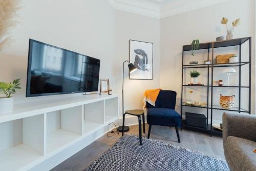 a living room with a flat screen tv on a white entertainment center at Stylish Stirling Apartment - free parking in Stirling
