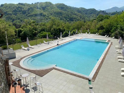 a pool with a pool table and chairs in it at Borgo Giusto Tuscany in Diecimo