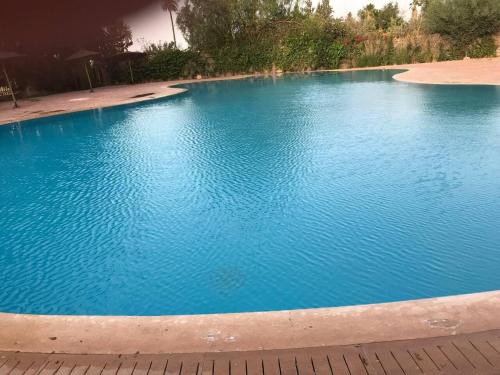 马拉喀什Beautiful Luxury 2 bedrooms Apartment in Marrakech的一个蓝色海水的大型游泳池