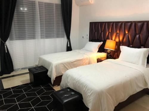 马拉喀什Beautiful Luxury 2 bedrooms Apartment in Marrakech的有两张床和一扇窗户的酒店房间