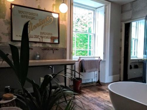 a bathroom with a tub and a sink and a window at Treventon, 5 bedroom Unique Villa, near PADSTOW in Saint Columb Major