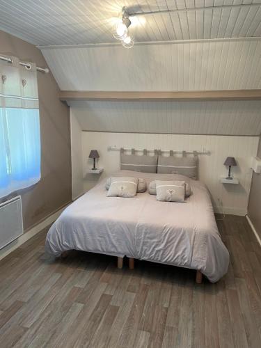 une chambre avec un grand lit blanc avec deux oreillers dans l'établissement Gites des marronniers proche du Tréport, à Saint-Martin-le-Gaillard