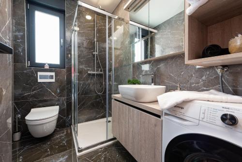 a bathroom with a washing machine and a sink at Villa Blue Sky 2 ZadarVillas in Turanj