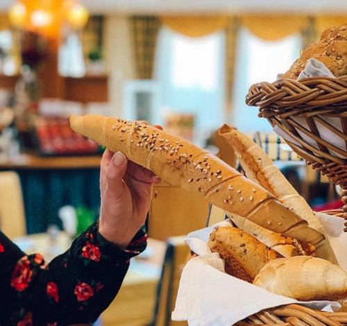 a person is holding up a basket of hot dogs at Hotel Alexandra in Wels