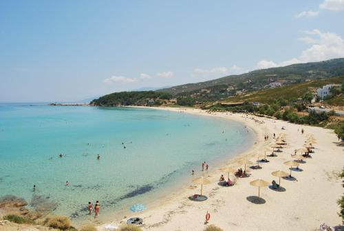 a beach with umbrellas and people in the water at Erofili Beach Hotel in Armenistis