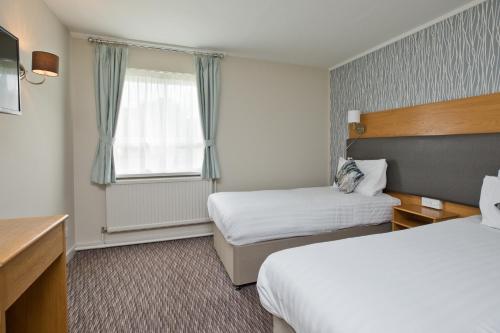 a hotel room with two beds and a window at Blue Bell Lodge Hotel in Middlesbrough