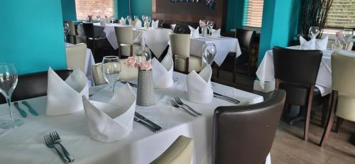 un tavolo con tovaglioli bianchi e bicchieri da vino sopra di Bennetts Hotel a Long Eaton