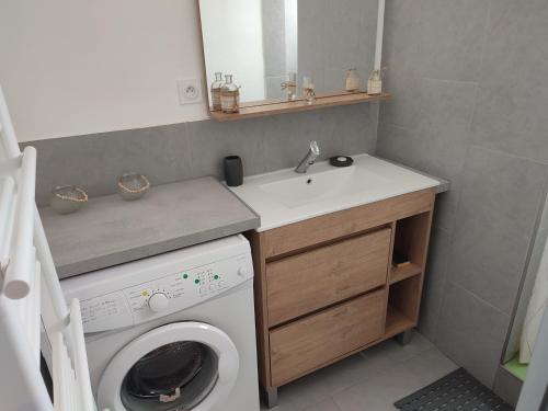 une petite salle de bains avec un lave-linge et un lavabo dans l'établissement T3 45M2, Cap d'Adge,Secteur Falaise,4-6 pers, Clim, Fibre - WIFI, 100m plage, au Cap d'Agde