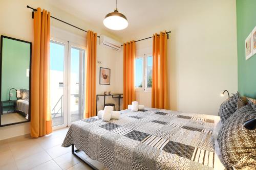 una camera da letto con un grande letto con tende arancioni di Art Garden house - 500m from the Beach a Gournes