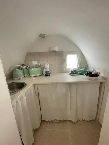 a kitchen counter with a sink and a window at Dimora L’Antico Bijou in Ostuni