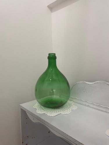 a green glass vase sitting on top of a table at Dimora L’Antico Bijou in Ostuni