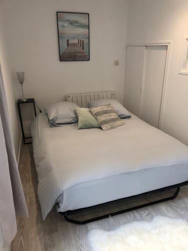 a bedroom with a white bed with two pillows at L'étape de la Tour in Grand-Fougeray
