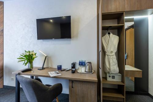 a room with a desk with a suit hanging on a wall at Ribas Rooms Bila Tserkva in Bila Tserkva