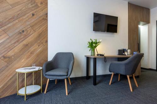 a room with two chairs and a table and a tv at Ribas Rooms Bila Tserkva in Bila Tserkva