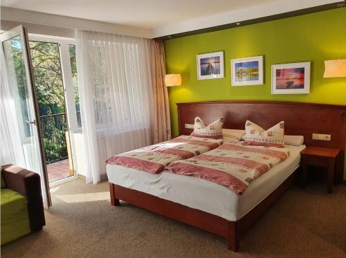 a bedroom with a large bed with green walls at Hotel Dlugie in Strzelce Krajeńskie