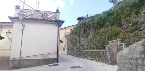 an empty alley with a stone wall and a white sign at Casa caratteristica nel Parco del Cilento in Cuccaro Vetere