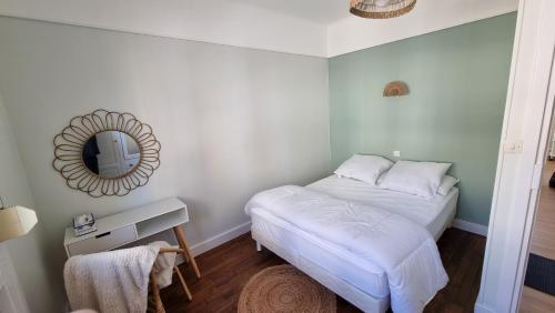 una piccola camera con letto e specchio di Appartement BERCK à deux pas de la plage a Berck-sur-Mer