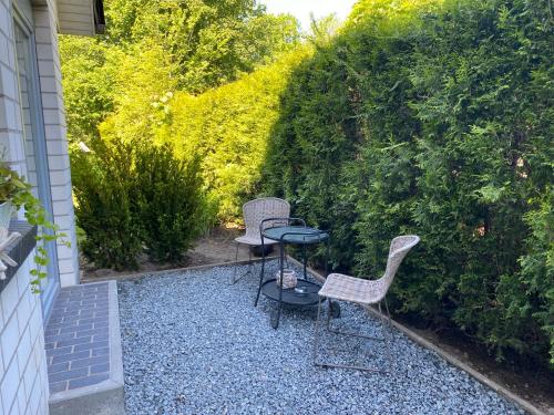 a patio with two chairs and a table on gravel at Appartement Delfi in Flensburg