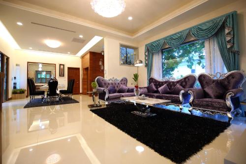 a living room with purple couches and a table at White Palace B&B in Jian