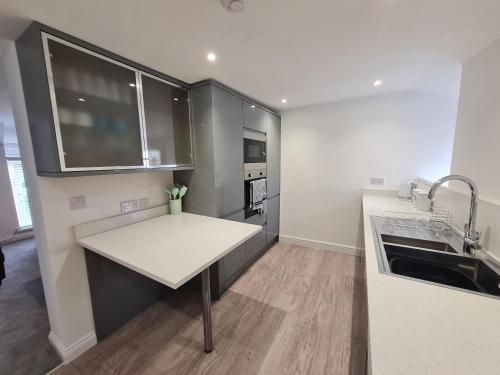 a kitchen with a sink and a counter top at Perfect Location 3 Bed Serviced apartment with Bike Storage for BPW. Close to Brecon Beacons in Merthyr Tydfil