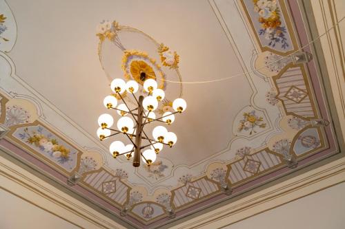 een kroonluchter aan het plafond van een kamer bij Palazzo Guajana in Trapani