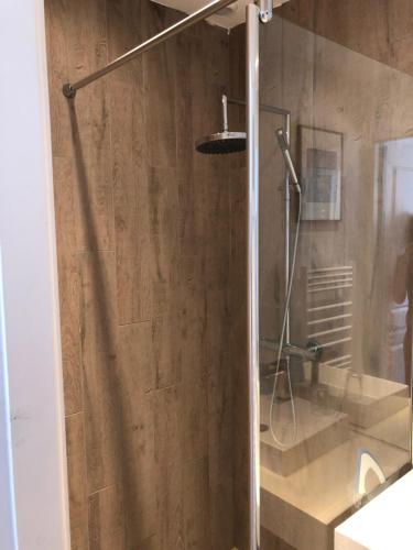 une douche avec une porte vitrée dans une salle de bain dans l'établissement studio avec terrasse et jardin à 3 minutes à pied de la plage, à Canet