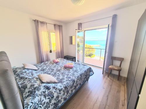 um quarto com uma cama e vista para o oceano em Beachfront 5BR Home Victoria em Kukljica