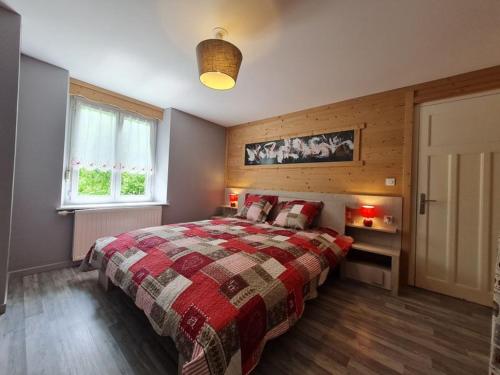 um quarto com uma cama grande e uma janela em Appartement les champis em La Bresse