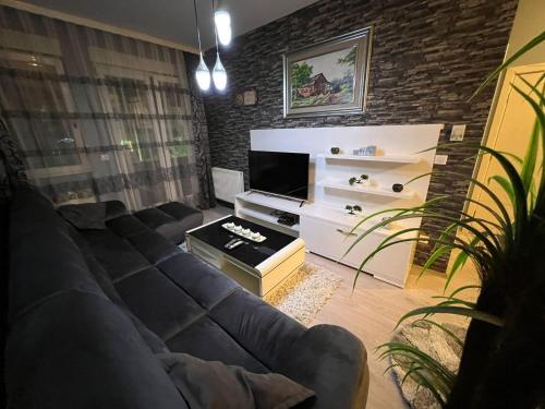 a living room with a couch and a television at Luxurious Apartment in Prishtinë