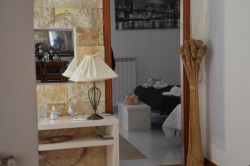 un soggiorno con tavolo, lampada e specchio di Il Sogno Caltagirone a Caltagirone