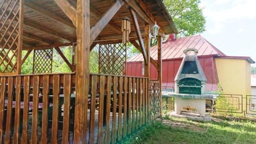 a wooden pavilion with a bell in front of a barn at Chalupa Krušné hory in Potŭčky
