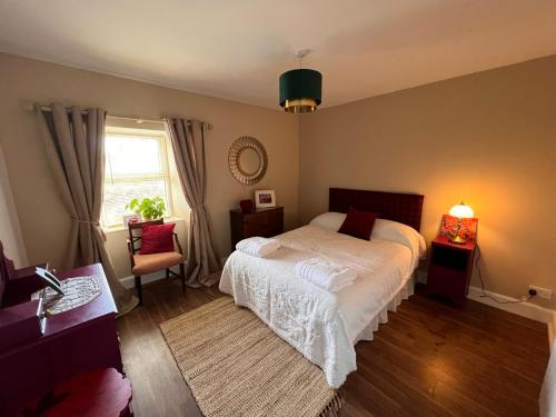 sypialnia z łóżkiem, krzesłem i oknem w obiekcie Berry View - Idyllic cosy cottage on berry farm w mieście Blairgowrie