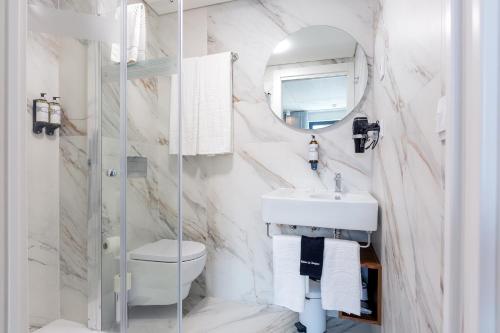a white bathroom with a sink and a mirror at Bemyguest - Loft Guest House Jardim das Mães Charming in Viseu