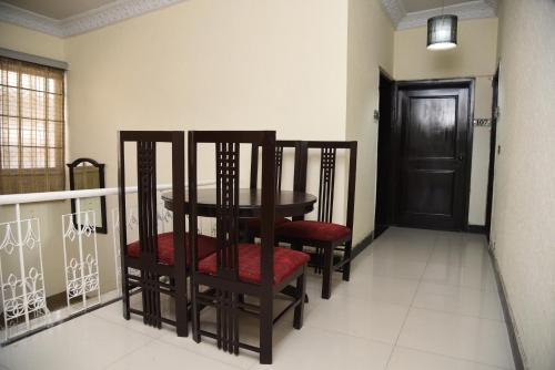 a dining room with a table and chairs and a door at Star House in Islamabad