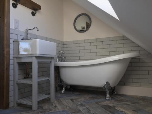 Et badeværelse på Deer Den timber clad cabin with hot tub, up private lane