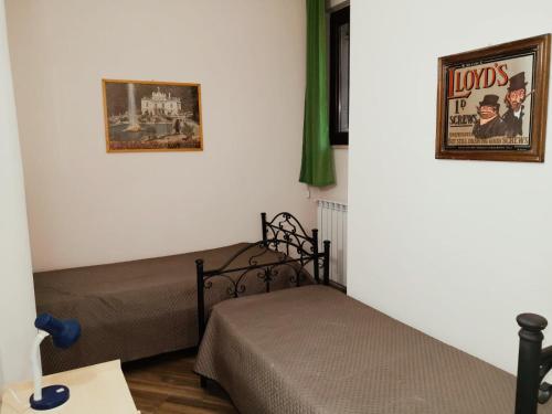 a bedroom with two beds and posters on the wall at Da Nonna Cettina Appartamento in villa con piscina in Palermo