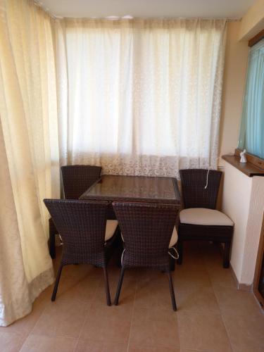 a dining table and chairs in a room with a window at Студио в комплекс Golden Beach, Sunny Beach in Sunny Beach