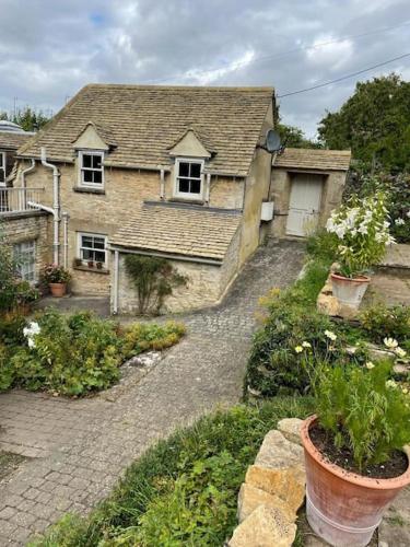 a house with a stone path leading into a yard at Masons Cottage, an Idyllic retreat in an area of outstanding beauty, close to Blenheim Palace, Oxford & The Cotswolds in Stonesfield