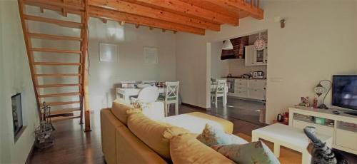 Casa de campo a 5 minutos da praia في Atouguio: غرفة معيشة مع أريكة وغرفة طعام
