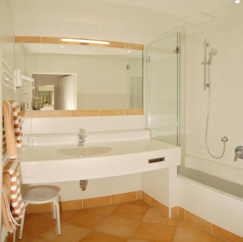 a bathroom with a sink and a shower at Landhotel Kielhuberhof in Ramsau am Dachstein
