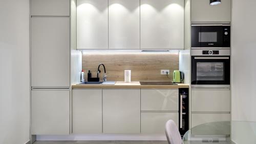 a kitchen with white cabinets and a sink at Apartman Nostra 1 in Zagreb
