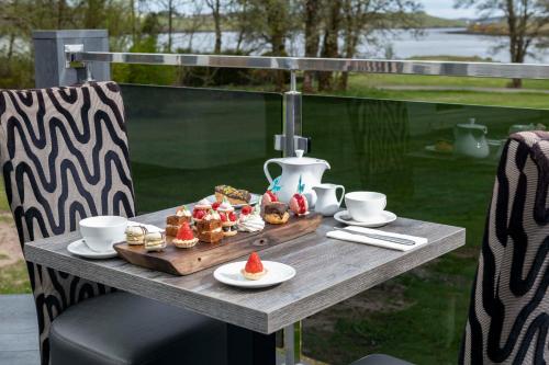 a table with a tray of pastries and cups on it at Skeabost House Hotel in Portree