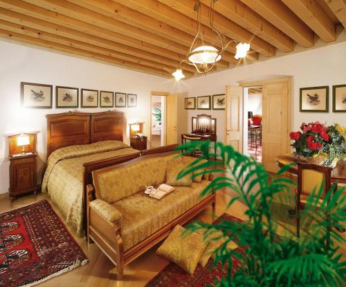 1 dormitorio con 1 cama y 1 sofá en Villa Busta Hotel, en Montebelluna
